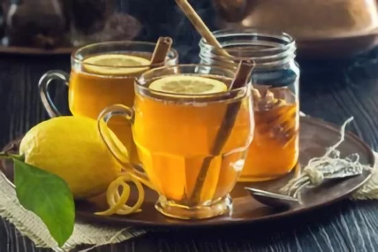 Tasses de boisson chaude citronnée avec bâtons de cannelle et rondelles de citron.