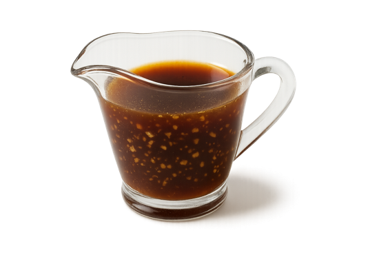 Sauce pour grillades à base d’huile d’olive, vin rouge et ail dans une coupelle en verre.