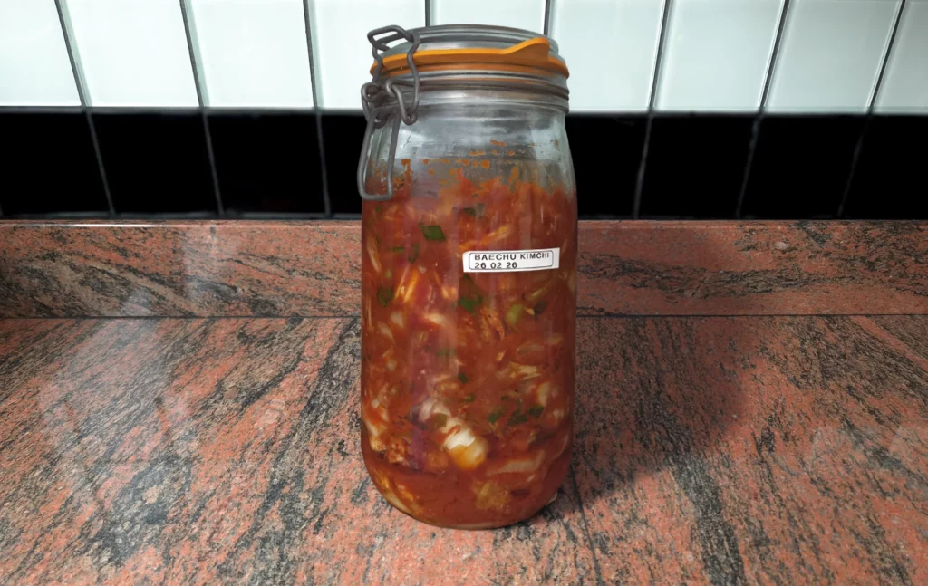 Bocal de kimchi maison au chou chinois (baechu kimchi) sur plan de travail