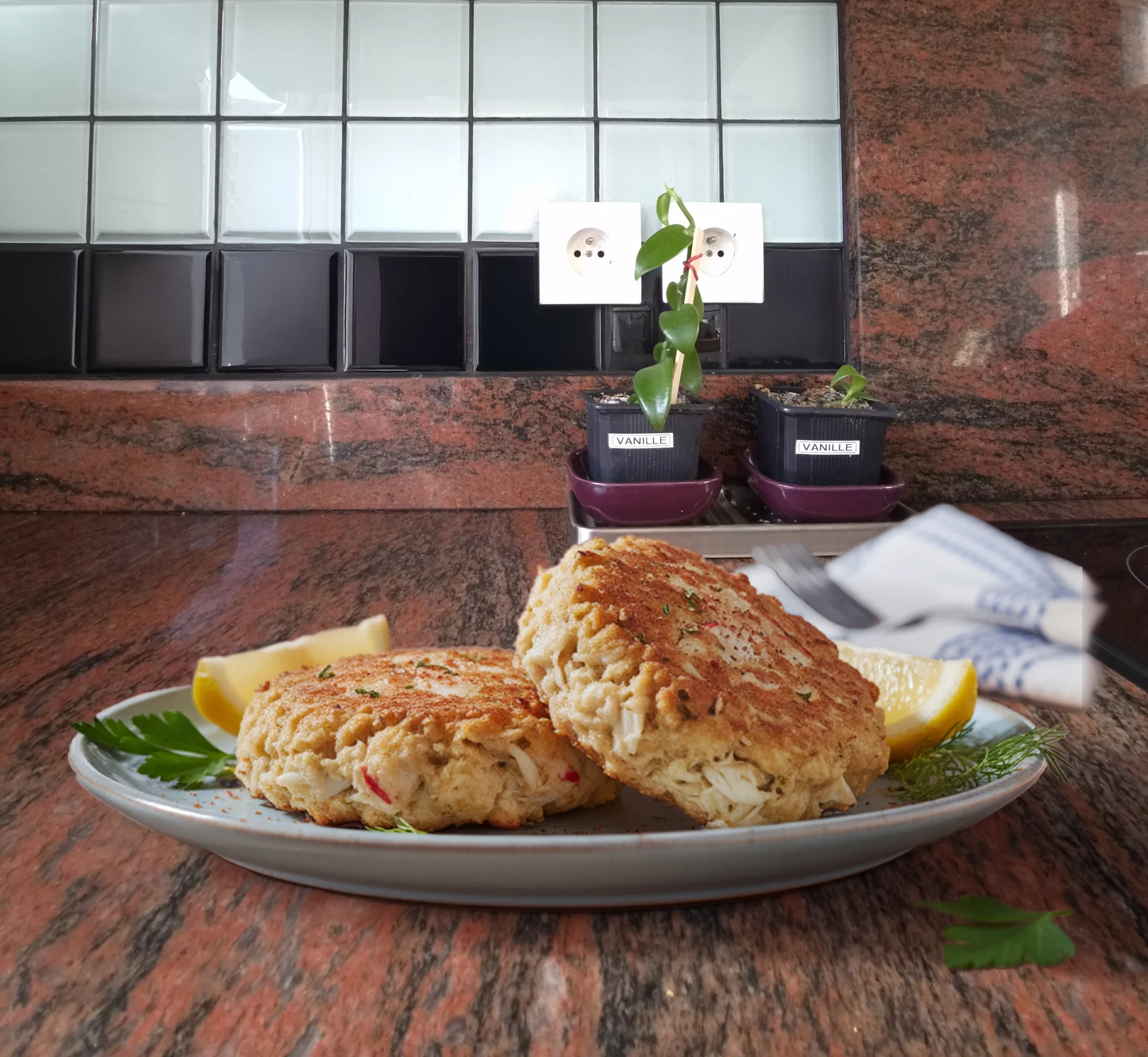 Galettes de crabe dor&eacute;es avec citron et herbes fra&icirc;ches.