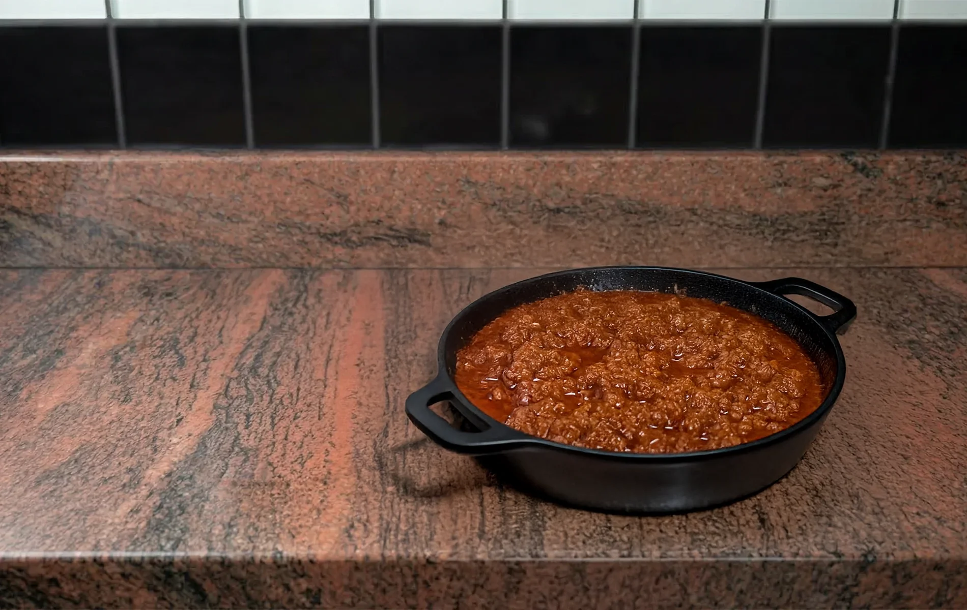 Affiner une photographie de sauce bolognaise maison dans une casserole en fonte : conserver la composition et le cadrage actuels, am&eacute;liorer l&eacute;g&egrave;rement le r&eacute;alisme de la surface avec des variations naturelles de texture et de brillance. Ajouter une l&eacute;g&egrave;re vapeur discr&egrave;te sugg&eacute;rant une cuisson r&eacute;cente. Introduire de tr&egrave;s fines traces de cuisson sur le bord int&eacute;rieur de la casserole. Lumi&egrave;re naturelle douce l&eacute;g&egrave;rement plus directionnelle pour renforcer les reliefs, sans effet stylis&eacute;. Rendu photographique r&eacute;aliste, subtil, sans modification de la sc&egrave;ne ni ajout d&rsquo;&eacute;l&eacute;ments.