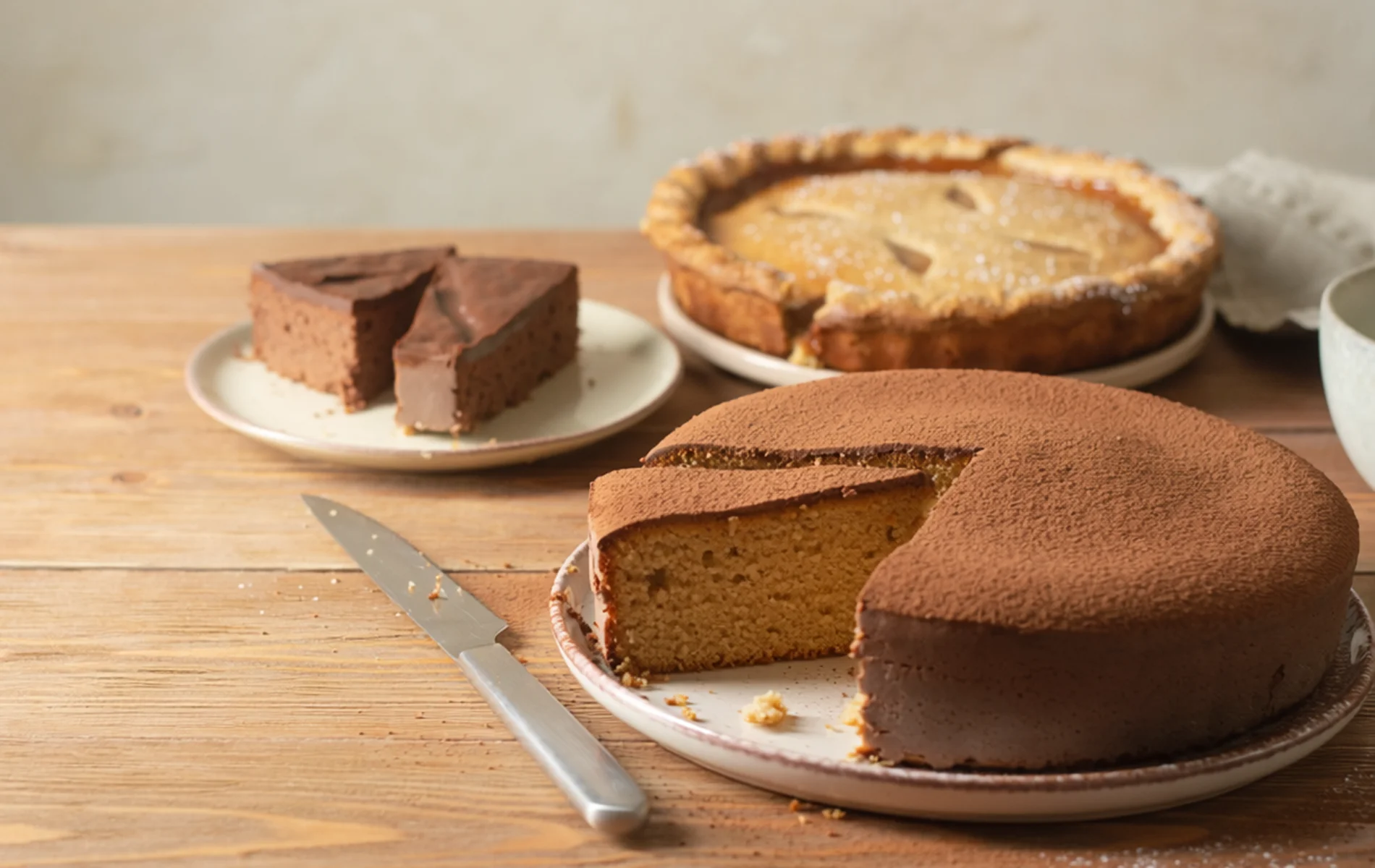 Gâteau à partager coupé avec parts visibles, lumière naturelle, ambiance conviviale, style photo culinaire réaliste.