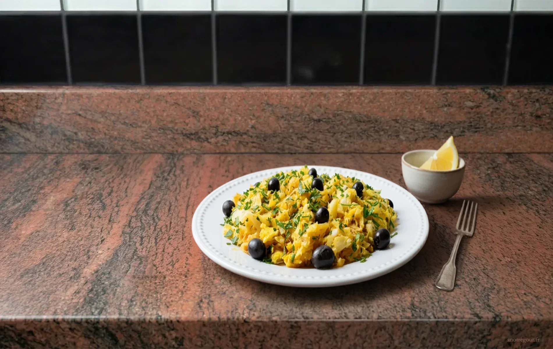 Morue &agrave; Br&aacute;s portugaise avec pommes paille, &oelig;ufs cr&eacute;meux, persil et olives noires, servie dans une assiette sur plan de travail en granit.