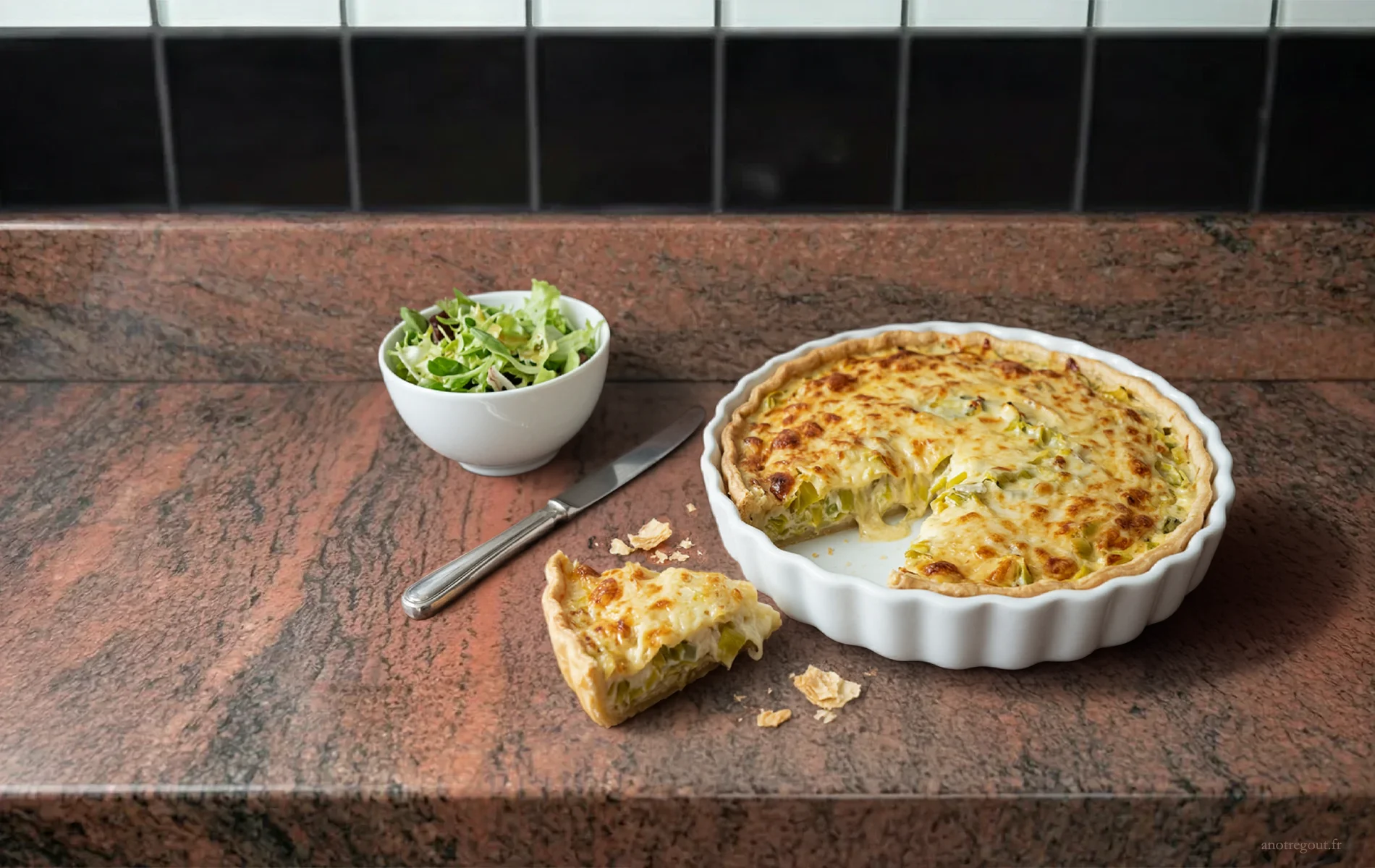 Tarte aux poireaux fondante avec part d&eacute;coup&eacute;e, accompagn&eacute;e d&rsquo;une petite salade verte