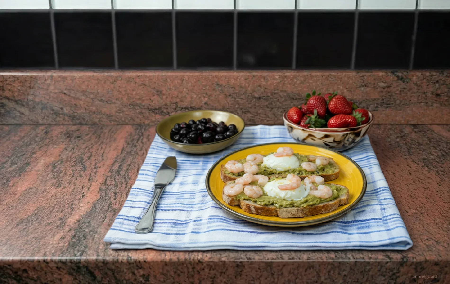 Tartines avocat avec &oelig;ufs poch&eacute;s et crevettes, bols de myrtilles et fraises.