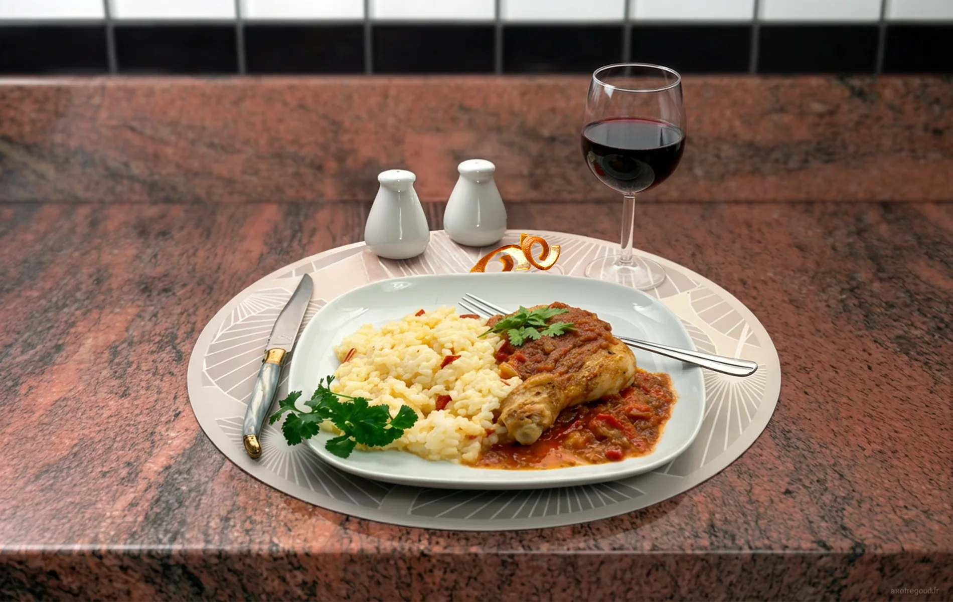 Assiette de poulet basquaise servie avec riz et sauce aux poivrons.