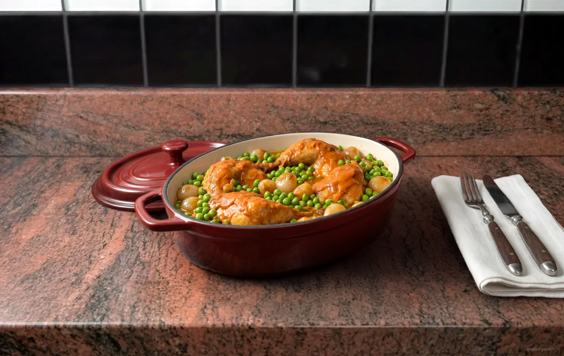 Cocotte de pintade aux petits pois et petits oignons sur un plan de travail en granit.