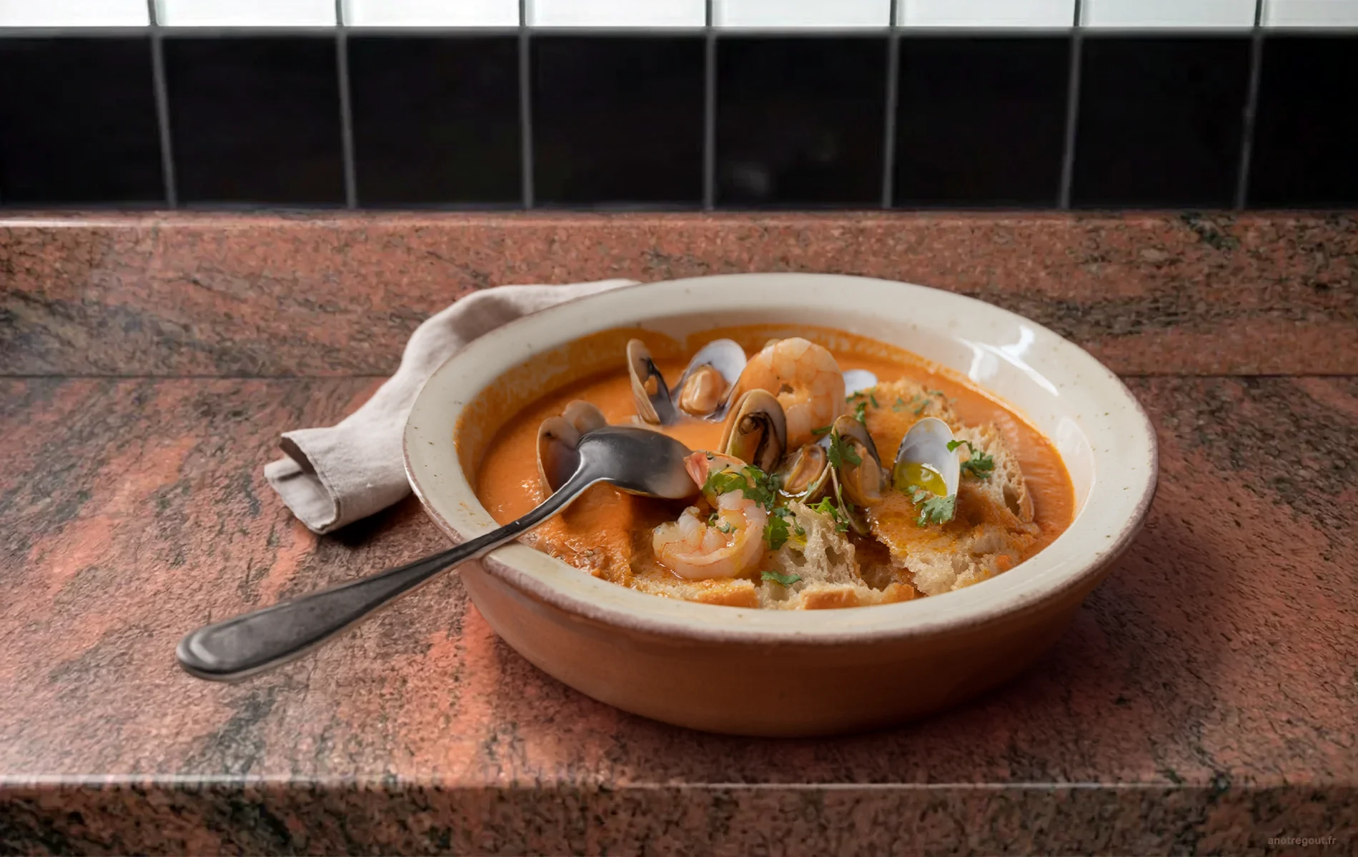 A&ccedil;orda de marisco servie dans un plat creux, avec fruits de mer, pain moelleux et coriandre fra&icirc;che.